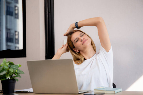 Portrait young caucasian businesswoman taking a break after overworked with stretching arm and hand in living room at home office, business woman relax with ergonomic, business and health.
