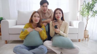 Asyalı grup arkadaşları korku ve sürprizle dolu bir korku filmi izliyorlar. Evdeki rahat bir oturma odasında birlikte oturuyorlar. Duygular, keyif alma, televizyon izlerken ifade verme..