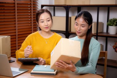 Çevrimiçi iş planlarken çalışan iki genç Asyalı kadın ve evde tablet ile sipariş kontrolü, çevrimiçi satıcı ile perakende satış, girişim işi ve kargo, nakliye ve hizmet.