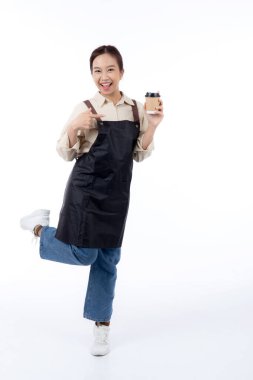 Portreli, genç Asyalı barista mutlu bir şekilde elinde bir kahve fincanı, izole edilmiş beyaz bir arka plan, neşeli bir barista hazır kahveyi sunuyor, küçük bir iş yeri ya da....