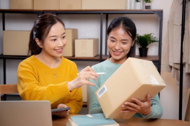 Çevrimiçi iş planlarken çalışan iki genç Asyalı kadın ve evde tablet ile sipariş kontrolü, çevrimiçi satıcı ile perakende satış, girişim işi ve kargo, nakliye ve hizmet.