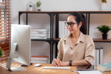 Mutluluk genç iş kadını masaüstü bilgisayarını evdeki oturma odasında kullanıyor, iş kadını internet, girişimci ya da serbest meslek ve iletişim için bilgisayar kullanıyor.