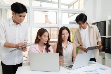 Genç Asyalı iş adamları modern ofisteki projede işbirliği, grup iş adamları pazarlama ve finans planı ve stratejisi için beyin fırtınası yapıyor, girişimin takım çalışması.