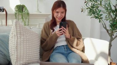 Genç Asyalı kadın akıllı telefonu evdeki Al Chatbot 'la sohbet etmek için kullanıyor. İletişim ve teknoloji. Akıllı telefondaki kadın sohbet robotu..