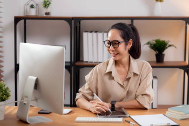 Çalışma odasındaki masaüstü bilgisayarına yazı yazarken mutlu genç iş kadını, bilgisayar kullanan iş kadını, girişimci ya da serbest çalışan, iş ve ticaret..