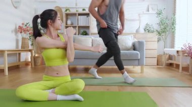 Genç Asyalı çift evdeki oturma odasında yoga ve meditasyon yapıyor, rahatlama, sağIık ve sağlıklı yaşam tarzı, yoga ve sağIık için spor yaparak sakin ve dingin bir yaşam sürüyor..