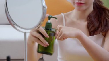 Kapalı eller güzel genç kadın losyon sürüyor evde aynaya bakıyor, güzellik kadın düşürücü serumu ellerinde gençleşme, kozmetik ve makyaj kişisel bakım, cilt bakımı ve sağlık için.
