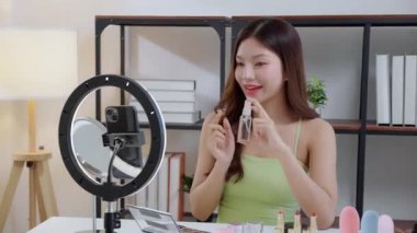 Genç Asyalı kadın yüz spreyi veya sosyal medyada serum, güzellik değerlendirmesi için içerik yaratıcısı, cilt bakımı ve kozmetik içeriği, güzellik ürünleri ve canlı yayın, yaşam tarzı ve cilt bakımı.