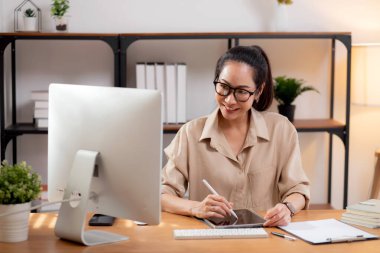 Çalışma odasındaki masaüstü bilgisayarına yazı yazarken mutlu genç iş kadını, bilgisayar kullanan iş kadını, girişimci ya da serbest çalışan, iş ve ticaret..