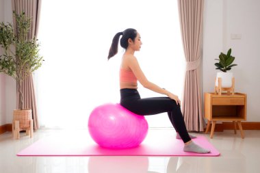 Evde yoga topuyla yoga yapan genç Asyalı kadın, sağlık ve dinlenme, eğitim sporu ve sağlık için hobisi olan kadın egzersizi ya da egzersiz yapıyor..