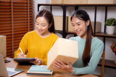 Çevrimiçi iş planlarken çalışan iki genç Asyalı kadın ve evde tablet ile sipariş kontrolü, çevrimiçi satıcı ile perakende satış, girişim işi ve kargo, nakliye ve hizmet.