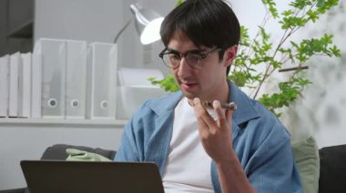 Beyaz adam ev telefonunda yapay zeka asistanıyla konuşuyor. Uzaktan kumandalı iş, serbest meslek, akıllı telefon sohbet botu sohbeti, serbest çalışan düşünme, modern dijital iş akışı, iletişim yapay zekası..