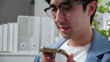 Beyaz adam ev telefonunda yapay zeka asistanıyla konuşuyor. Uzaktan kumandalı iş, serbest meslek, akıllı telefon sohbet botu sohbeti, serbest çalışan düşünme, modern dijital iş akışı, iletişim yapay zekası..