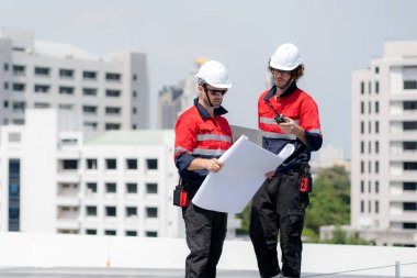 Güneş enerjisi sistemini kontrol eden iki mühendis, kurulum güneş paneli, yenilenebilir enerji ve sürdürülebilir teknoloji, temiz elektrik, sanayi ve güneş hücresi planlama projesini birlikte inceliyor..