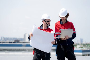 Güneş enerjisi sistemini kontrol eden iki mühendis, kurulum güneş paneli, yenilenebilir enerji ve sürdürülebilir teknoloji, temiz elektrik, sanayi ve güneş hücresi planlama projesini birlikte inceliyor..