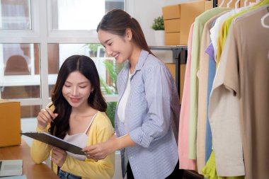 Çevrimiçi iş ve düzeni, girişimciyi ve küçük işletmeyi yönetirken ve planlarken, belgeyi kontrol ederken ve kontrol ederken, Asyalı iki kadın, çevrimiçi satıcı ile perakende satış, girişim işi.