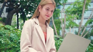 Genç Kafkasyalı iş kadını bilgisayar parkında çalışıyor, serbest çalışan ya da dijital göçebe, uzaktan çalışma teknolojisi çevrimiçi, iş kadını konsantrasyonu internetteki bilgisayarla dizüstü bilgisayarı yazıyor..
