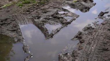 Yağmur sırasında toprak yolun yukarısında. Kırık toprak toprak toprak toprak yol. Su birikintisindeki tekerlek izi. Yaklaş.