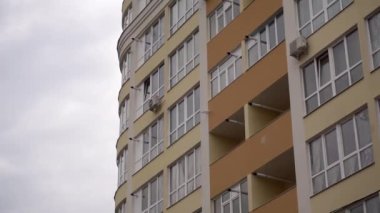 Pencereler çok katlı yeni bir binanın ön cephesinde. Yeni inşa edilmiş bir apartmanın otomatik ısıtma boruları.