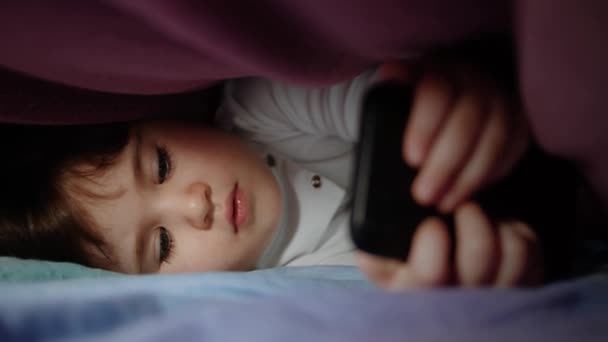 Kleines Mädchen Spielt Nachts Unter Einer Decke Smartphone Ein Eifriges — Stockvideo