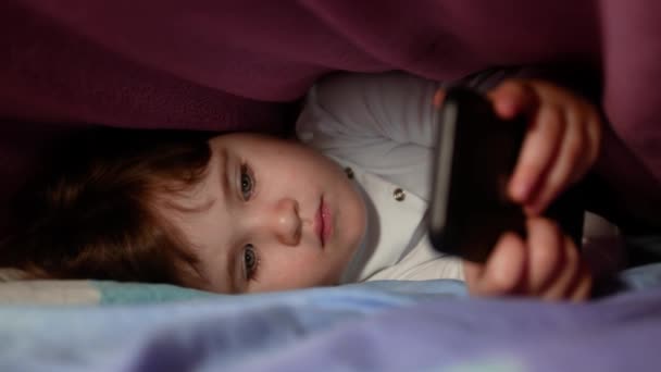 Mała Dziewczynka Bawi Się Smartfona Pod Kocem Nocy Bystry Dzieciak — Wideo stockowe