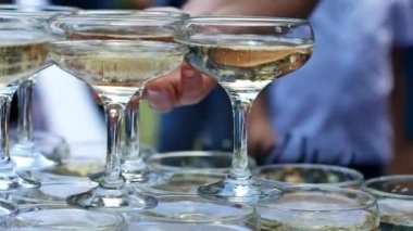 Guests are treated to snacks and sparkling wine during an open-air banquet. Champagne pyramid during an outdoor event.
