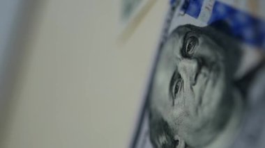 Yakın çekim makro çekim videosu. 1 dolarlık banknotta her şeyi gören bir gözün olduğu bir piramit. Üzerinde Benjamin Franklin 'in portresi olan 100 dolarlık bir banknot. Komplo teorisi. ABD banknotları, para.