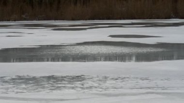 Reflection of the sky in the river water. Melting ice in the spring. Ice melts on the river. Ice crack. Spring sunny morning