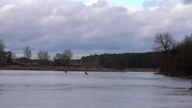 Balıkçılar kış balıkçılığında balık yakalar. Tehlikeli ince buz, insanlar buzda balık avlama riskini göze alır..
