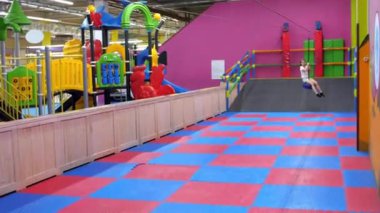 Okul çağındaki mutlu bir kız çocuk oyun odasında bungee 'ye biniyor. Eğlence merkezinde binicilik yapan neşeli genç bir kızın süper yavaş çekimleri. Neşeli çocuklar.