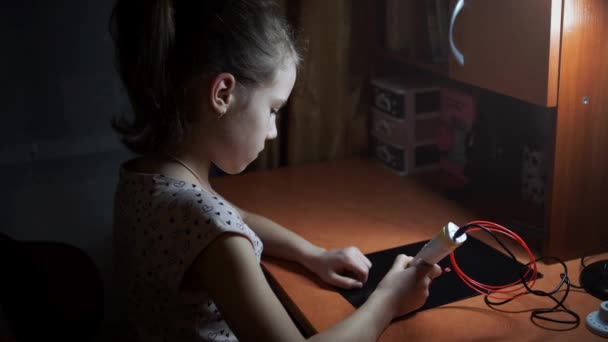 一个女孩用3D笔画出了一颗心 女儿创造了一个漂亮的粉红色钥匙链 作为礼物妈妈在母亲节或爸爸在父亲节 特写工作3D笔 — 图库视频影像