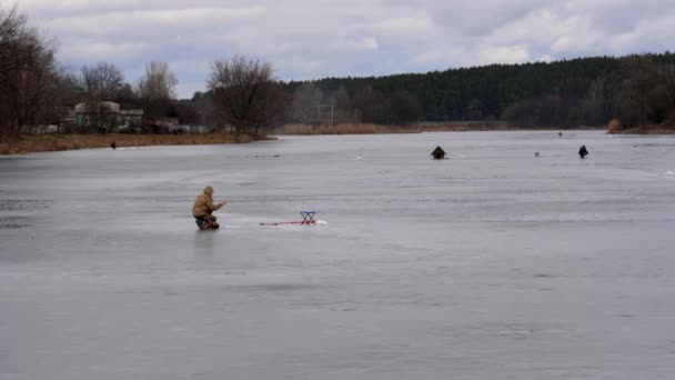 漁師は冬の釣りで魚を捕まえる 危険な薄い氷 人々は氷から釣りを危険にさらす — ストック動画