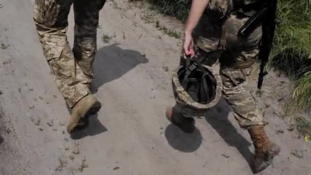 乌克兰武装部队的一名女兵走在路上 手里拿着防弹头盔 身着卡其布制服的士兵或军官被派去执行任务或军事任务 — 图库视频影像