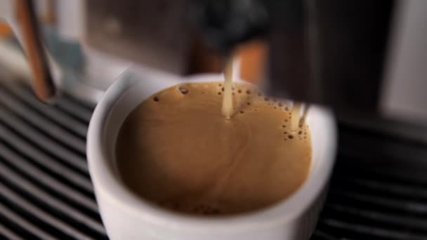 コーヒーマシンからカップに注ぎ込まれるコーヒーのクローズアップ遅い動き 朝食のために朝コーヒーを作る — ストック動画