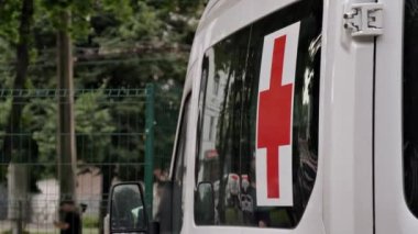 Kaykay parkının arka planında tıbbi araç var. Kaykay, scooter ya da bisikletle yapılan ekstrem sporlarda yaralanmalar. Çağrıya bir ambulans geldi, oyun alanına..