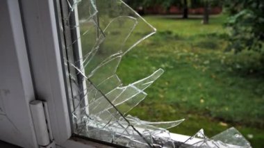 Dışarıya kırık cam pencereden bak. Kırık bir pencere manzarasında, evin içinden büyük cam kırıkları..