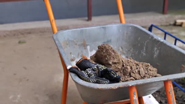 Construction Gloves Lying Pile Sand One Wheeled Wheelbarrow Repair Construction — Stock Video