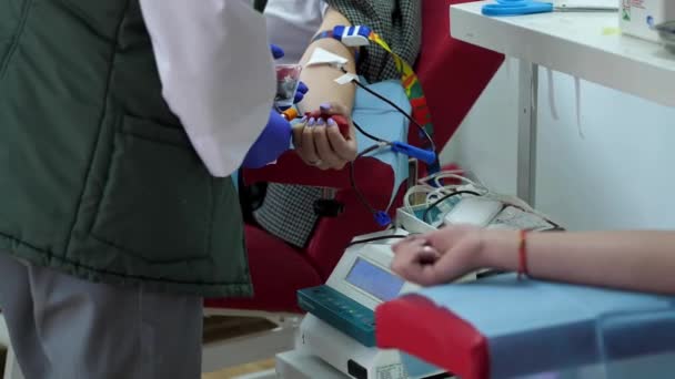 2022年9月 乌克兰切尔尼赫夫 一名献血女孩手里拿着一颗心脏形状的橡胶梨 在医院里给一个献血的志愿者割伤的照片 献血时的女孩 — 图库视频影像