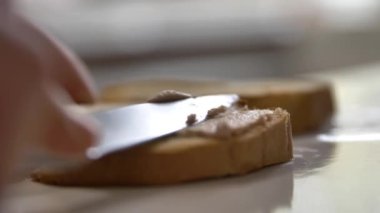 Tavuğun, ciğerin, balığın ya da et ezmesinin bıçakla yayıldığı bir tostun yakın çekimi. Ev yapımı iştah açıcı kahvaltı. Atıştırmalık sandviç..