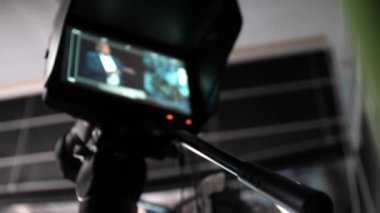 Talk show çekerken kamera monitörü. Canlı yayında ya da video yayınında profesyonel bir kameranın ekranında sunucu. TV kanalındaki TV stüdyosu. Üç ayaklı bir TV kamerası.