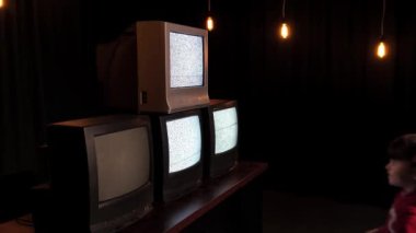 Küçük kız bir sürü arızalı televizyonu kapatıyor. Çocuk çalışmayan TV 'leri izliyor. Zombi TV konsepti. Propaganda ve televizyondan manipülasyon. Zombi kutusu. Televizyondan özgürlük. Kitle iletişim araçlarının yönlendirmeleri.