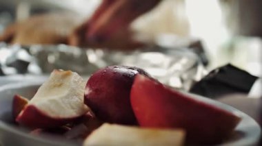 Çiğ ördek ya da kaz leşinin arka planına karşı bir çanakta elma parçalarını yakın çekim. Elma ve narenciye ile doldurulmuş kümes hayvanları..