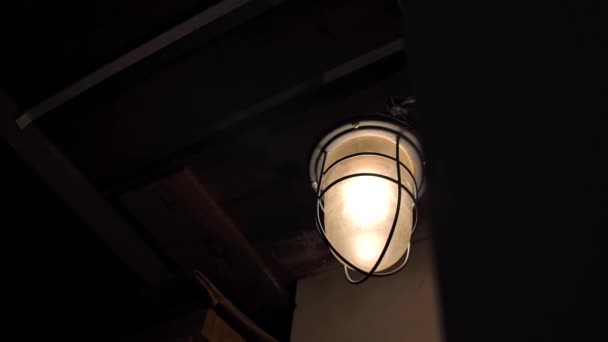 地下室或阁楼中的一盏旧灯的特写 旧式吊灯中的灯泡在旧的废弃房屋或建筑物的室内发光 — 图库视频影像