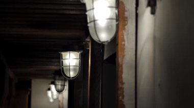 Bodrumda ya da tavan arasında birçok eski lambanın yakın çekimi. Eski, terk edilmiş bir evde ya da binada eski avizelerde parlayan ampuller..