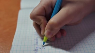 Öğrenci bir kız, Pazar günü ders verirken bir deftere bu kelimeyi yazıyor. Çocuk İngilizce ödev yapıyor ve haftanın günlerini yazıyor. Mesafe iç eğitim.
