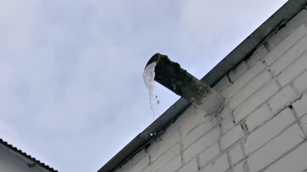 Hoch Über Dem Dach Hängt Ein Großer Schmelzender Eiszapfen Einem — Stockvideo