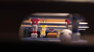 Langırt oyuncularının yakın çekim görüntüleri oyun sırasında döner. İnsanlar mini langırt oynuyorlar ve golle gol atıyorlar. Futbol kalesinden görüntü.