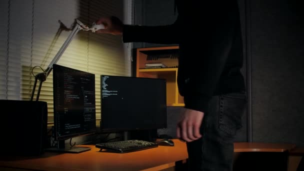 Hacker Computador Encapuzado Liga Uma Lâmpada Mesa Senta Local Trabalho — Vídeo de Stock