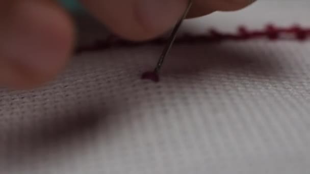 Kırmızı Iplikle Çapraz Dikiş Atarken Kumaşı Delen Bir Iğnenin Makro — Stok video