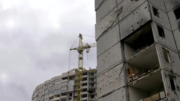 曇りの空に対する建設クレーン 爆発によって破壊された建物の再建または解体 ウクライナの修復住宅の建物は その結果 ロシアの軍事侵略に損傷しました — ストック動画